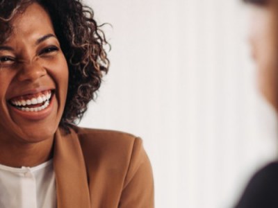 Smiling woman having a discussion with another woman across a table