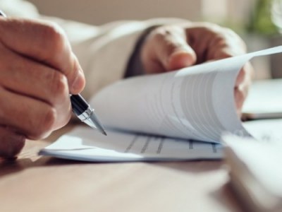 Person sitting at a business desk writing in a notebook